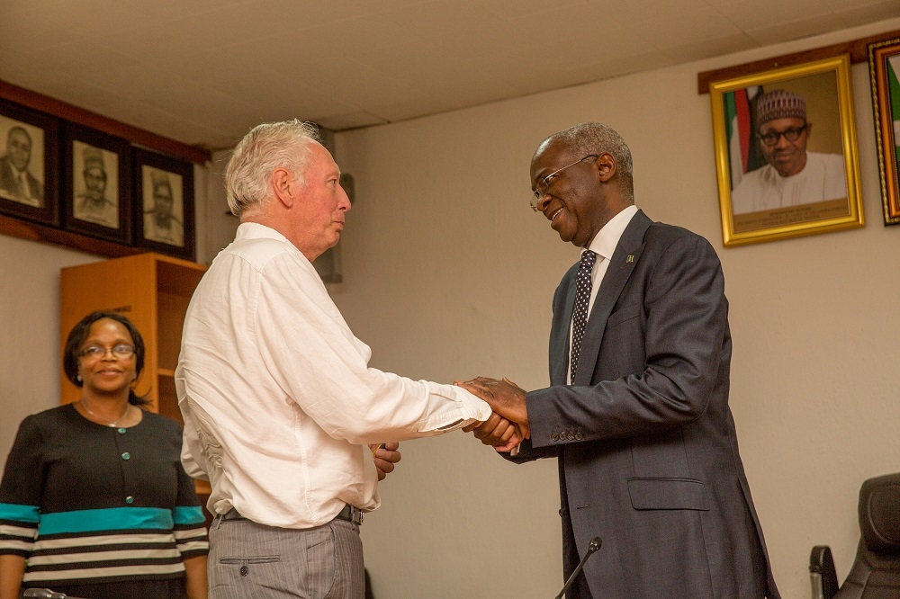 HonMinister of Power Works  Housing Mr Babatunde Fashola SAN right congratulatingformer Assistant Technical Adviser of the Super Eagles Bonfrere Joleft shortly afterhanding over the keys of the Federal Government allocated House to him in fulfillmentof Governments Pledge 24 years ago for Winning the 1994 African Cup of Nations at the Ministry of PowerWorks  Housing Headquarters Mabushi Abuja on Tuesday 5th June 2018