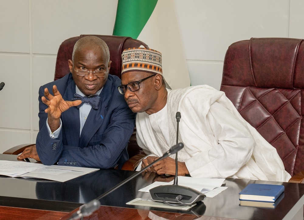 Hon  Minister of Works   Housing  Mr Babatunde Fashola SAN  left  and Permanent Secretary  Works   Housing  Mr  Mohammed Bukar right   during a courtesy visit by the Board of Directors of the Federal Mortgage Bank of Nigeria FMBN  at the Ministry of Works   Housing  Headquarters on Thursday  29th August 2019