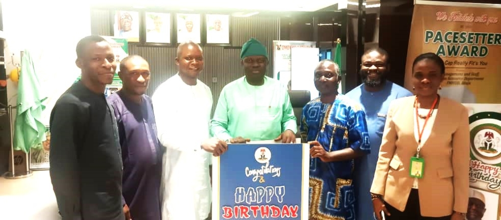 The Permanent Secretary, Federal Ministry of Housing and Urban Development, Dr. Marcus O. Ogunbiyi being presented with a birthday card on the celebration of his birthday at the Ministry’s Headquarter, Mabushi, Abuja.